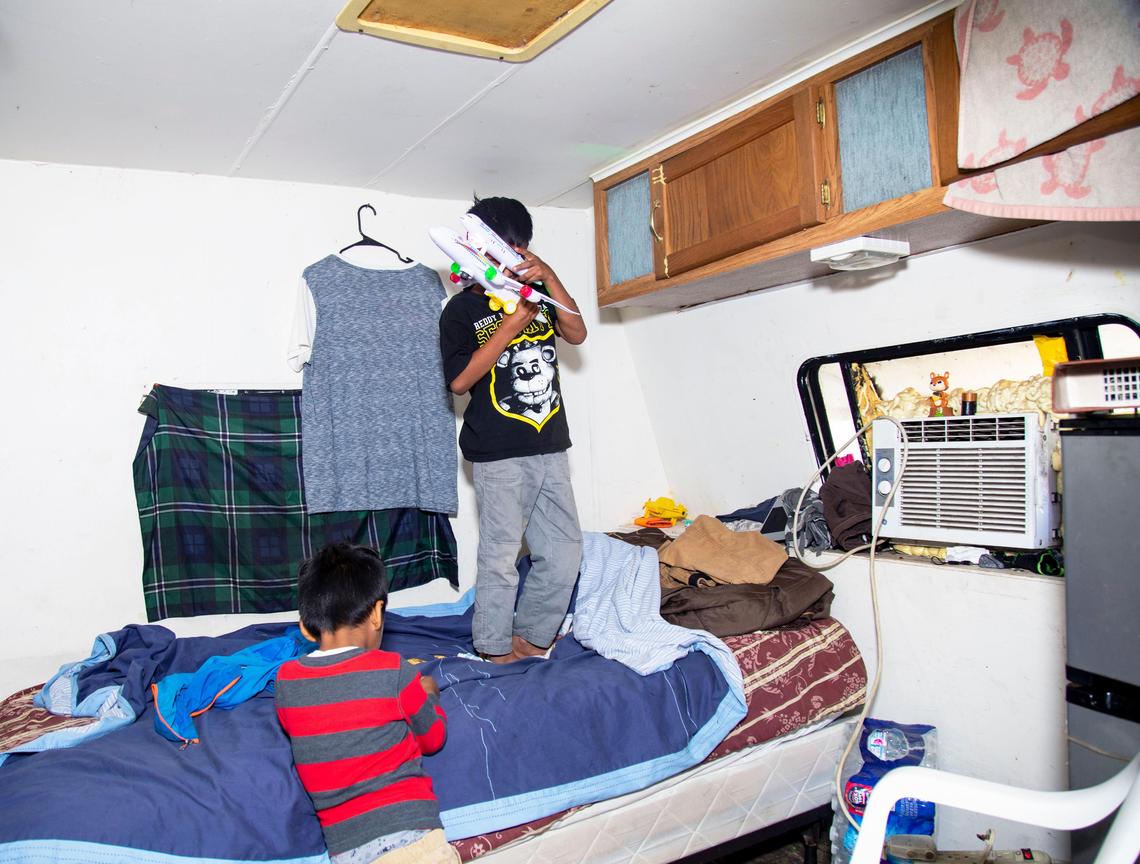 A migrant child plays inside the trailer he lives in at a secret migrant camp in South Miami-Dade.