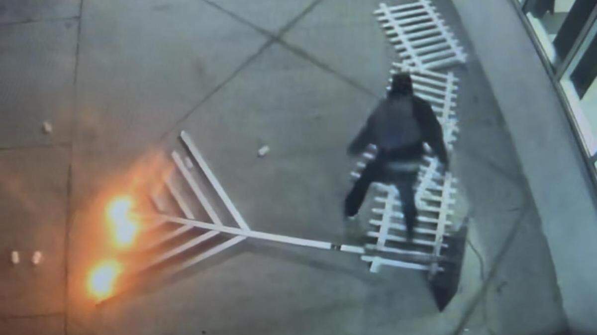 A man can be seen destroying a lit menorah displayed in front of the Miami-Dade County Tax Collector’s office in downtown Miami.