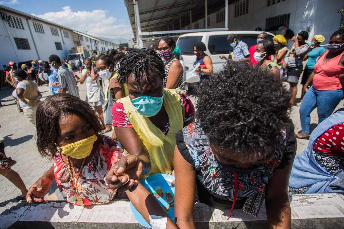 MBI workers wearing masks wash their hands during their lunch break at the MBI factory at the industrial park Sonapi in Port-au-Prince on April 21, 2020.