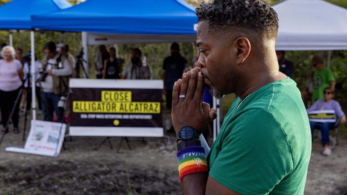 Unitarian Universalist Rev. Arthur Jones holds his hands up in prayer during a vigil outside Alligator Alcatraz on Sunday, October 19, 2025, in Ochopee, Fla.