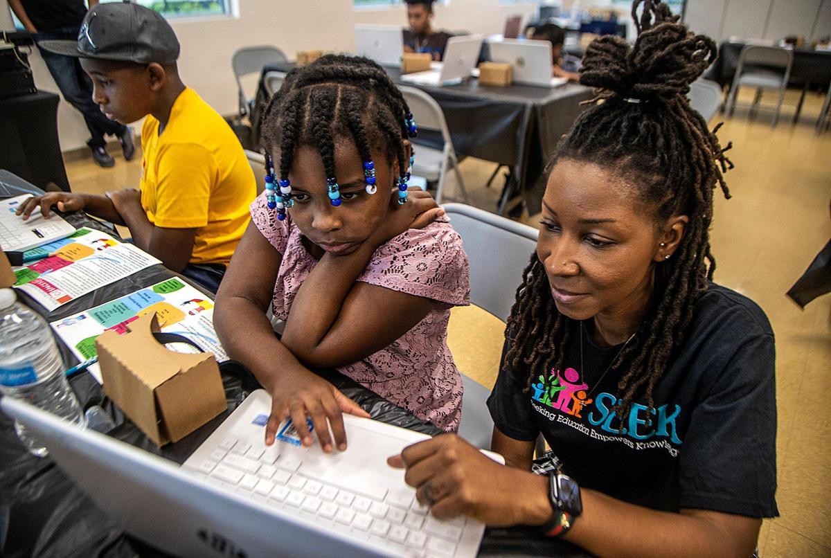 Instructor Crystal Jolly works with Abigail Dimanche on a project during a STEAMtastic Saturday in Miami Gardens on Oct. 15, 2022.