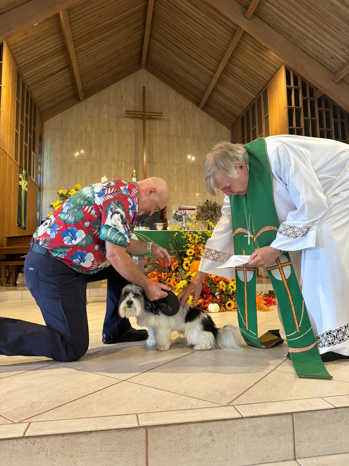 Pastor Terry Danger, right, blesses Hemingway, a Havanese dog owned by Andy Hudson, left, a long-time congregant at St John’s Lutheran Church in Hollywood.