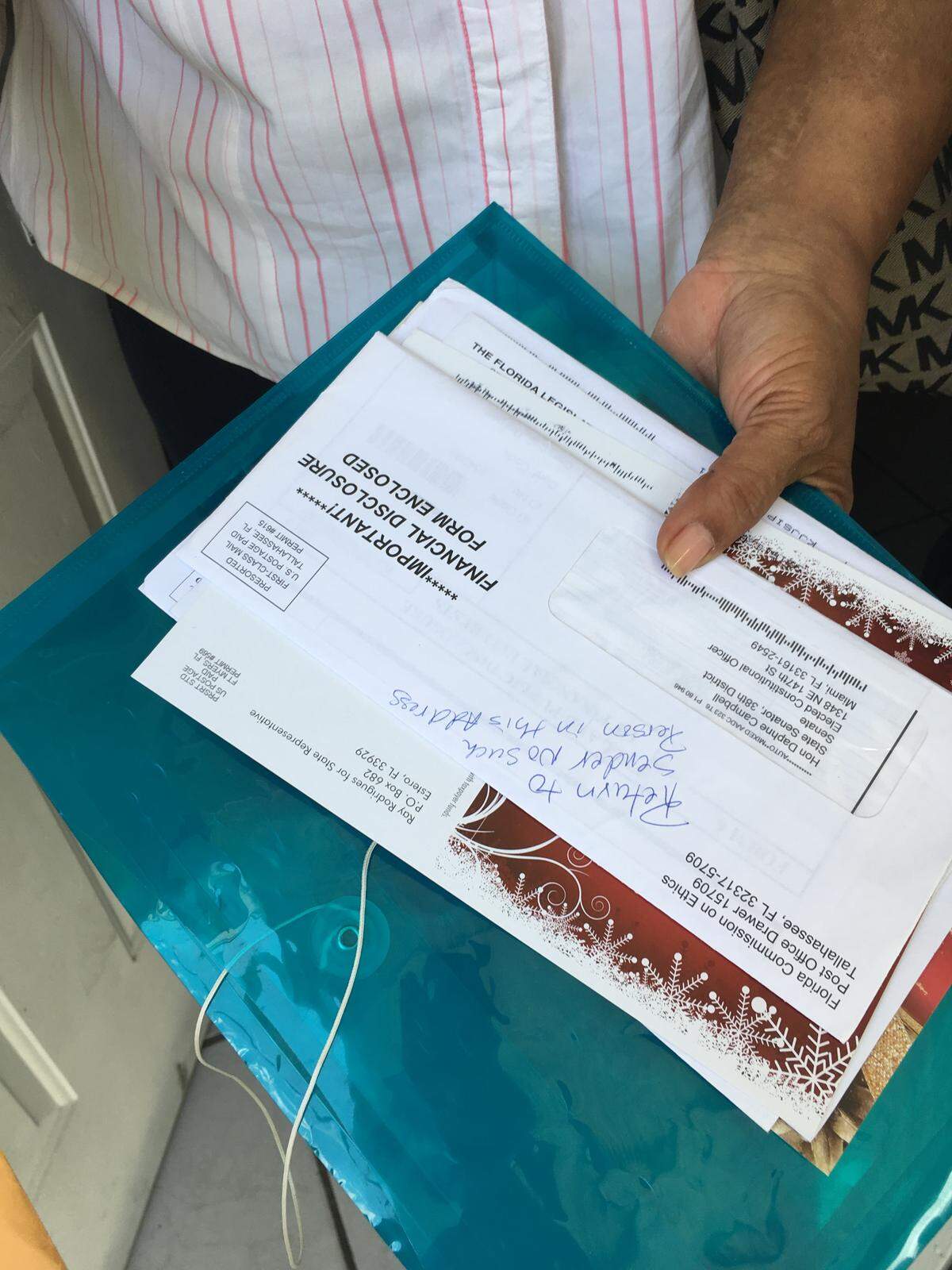 Carline Paul holds mail addressed to Daphne Campbell. Paul says she negotiated a lease with Campbell to move into her home shortly after she was elected to the Florida Senate. Campbell never moved in, but Paul started receiving mail for the Senator.