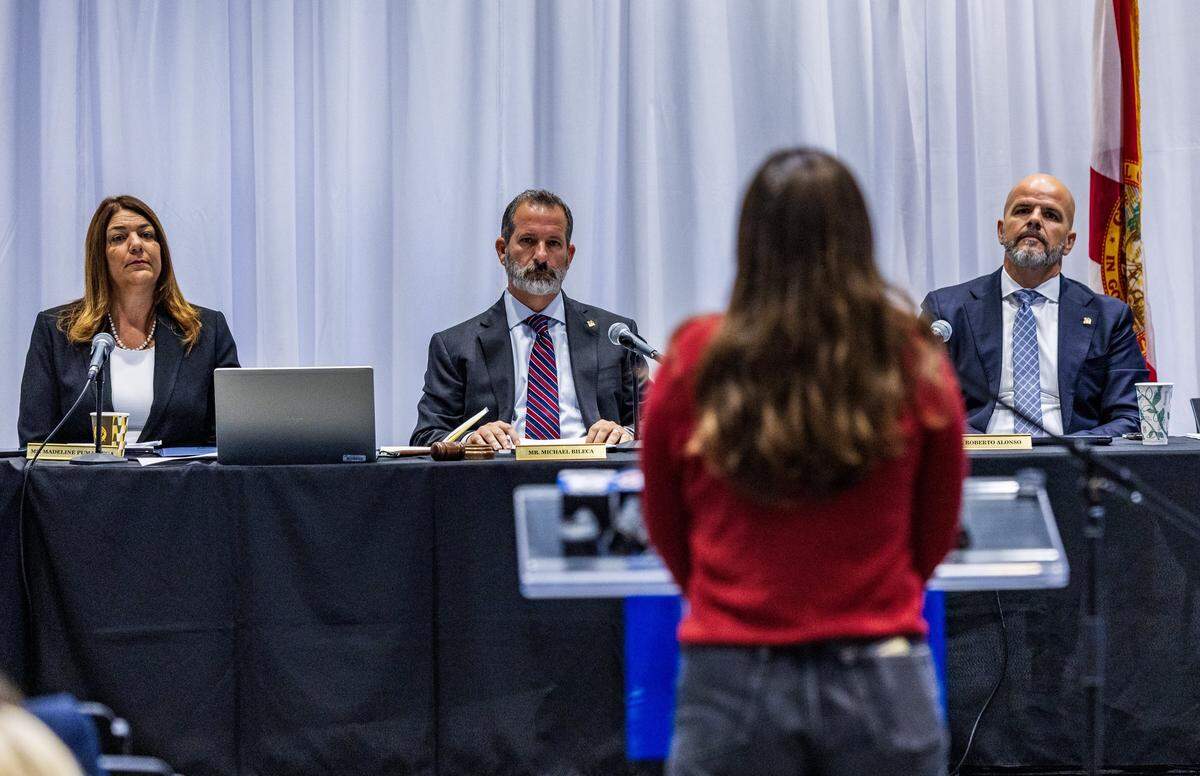 Miami Dade College President Madeline Pumariega and Board of Trustees members Michael Bileca (center) and Roberto Alonso,  listen as MDC alumna Katherine Kaiser speaks during a special meeting held to discuss the potential real estate transactions including the authorization to convey a +/-2.63 acre surface parking lot at the Wolfson Campus for further conveyance for a Presidential Library for Donald J. Trump, celebrated at the MDC Hialeah Campus, on Wednesday, December 02 , 2025. 
