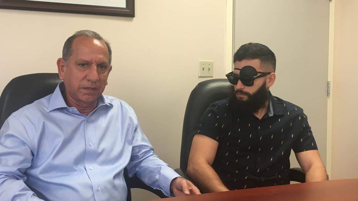 Eliel Flores sits next to his son Miami police officer Joseph Flores as he explains how the Police Officer Assistance Trust has helped his family since Joseph was diagnosed with a brain tumor.