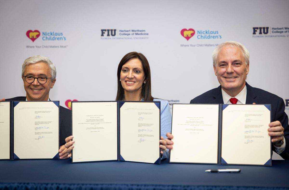 Dr. Juan Cendan, dean of FIU’s Herbert Wertheim College of Medicine, left, Jeanette Nuñez, interim president of FIU, center, and Matt Love, president and CEO of Nicklaus Children’s Health System, pose with a document announcing the launch of a new clinical, research and academic collaboration between FIU and Nicklaus Children’s Health System on Monday, May 19, 2025, at Florida International University campus in Miami, Fla.
