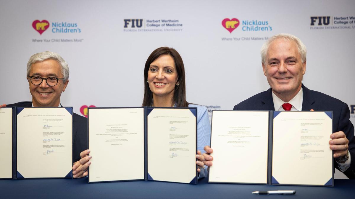 Sealing the deal. Juan Cendan, dean of FIU’s Herbert Wertheim College of Medicine, left, Jeanette Nuñez, president of FIU, center, and Matt Love, president and CEO of Nicklaus Children’s Health System, pose with a document announcing the launch of the new pediatric collaboration.