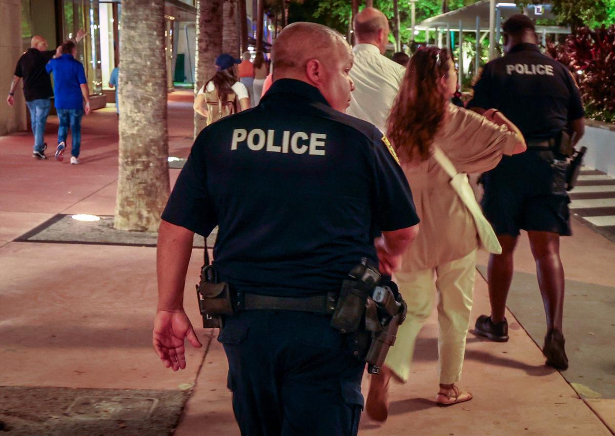Miami Beach police officers escort a team conducting a homeless point-in-time count on Lincoln Road Mall on Thursday, Aug. 22, 2024, in Miami Beach, Florida.