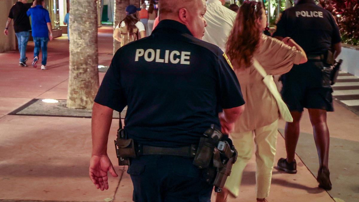 Miami Beach police officers escorts the homeless unsheltered canvassing team on Lincoln Road Mall on Thursday, August 22, 2024 in Miami Beach, Florida. Homeless Trust, along with Miami Beach officials, canvassed Lincoln Road Mall on Thursday, August 22, 2024, in Miami Beach, Florida, to attempt to count the unsheltered population as part of a broader Miami-Dade count.