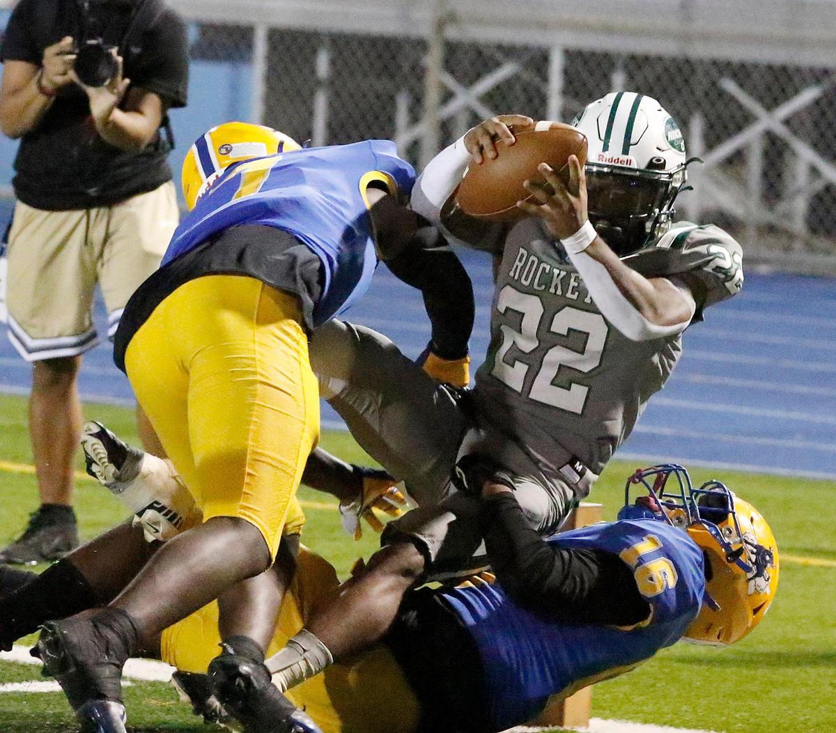 Northwestern Bulls defenders tackle Miami Central Rockets running back Jonathan Harris (22) during football game on Friday, October 7, 2022 at Traz Powell Stadium in Miami.