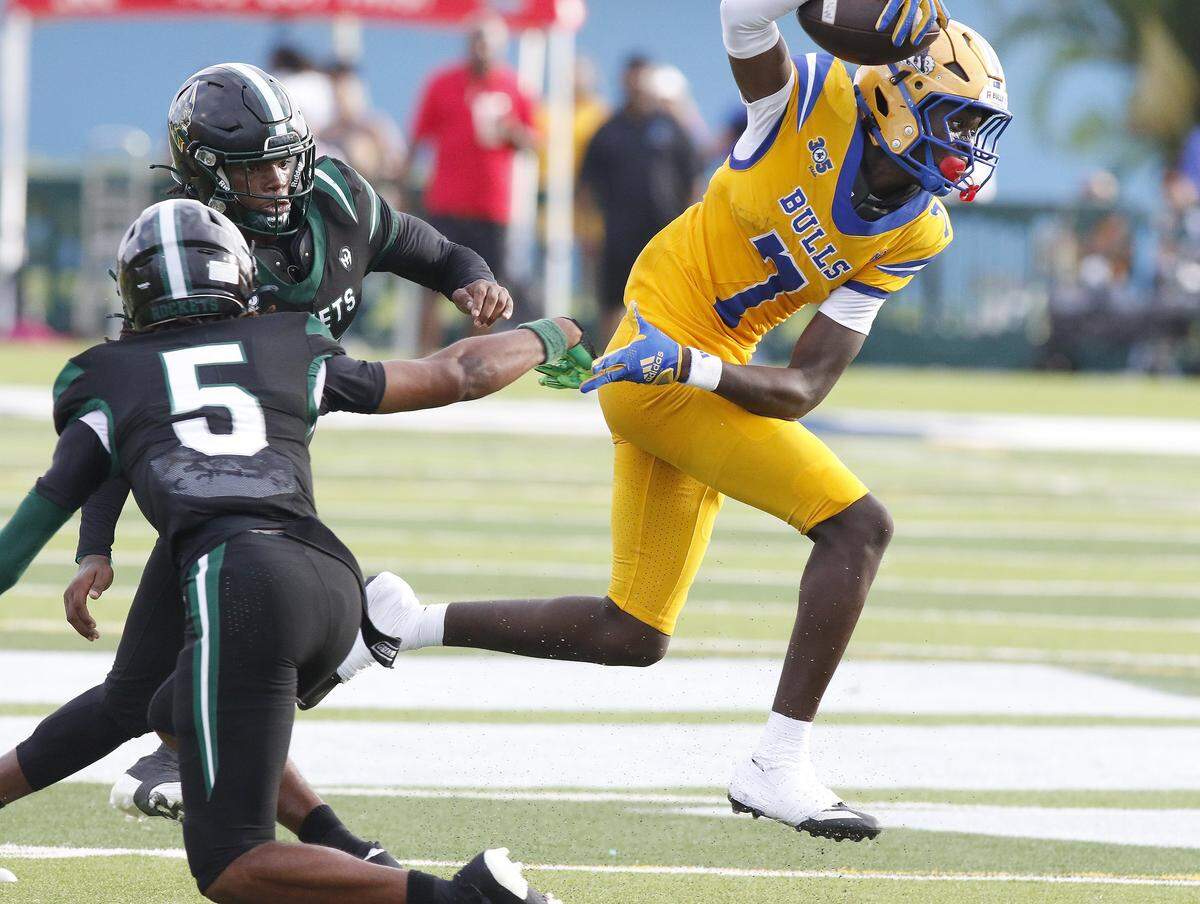 Northwestern Bulls wide receiver Nicsaint Joseph Jr. (7) escapes a tackle by Miami Central Rockets defenders during football game on Saturday, October 4, 2025 at Traz Powell Stadium in Miami. Andrew Uloza / for Miami Herald