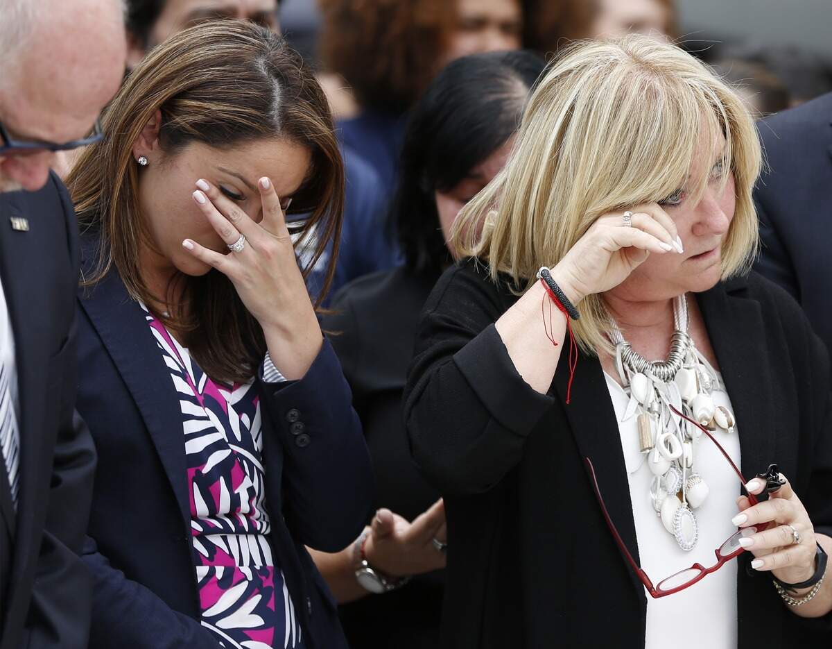 Breny Garcia, left, and Sandy Gonzalez Levy react as FIU holds a moment of silence to commemorate the one-year anniversary of the bridge collapse during a ceremony at Betty B. Chapman Student Plaza on Friday, March 15, 2019.