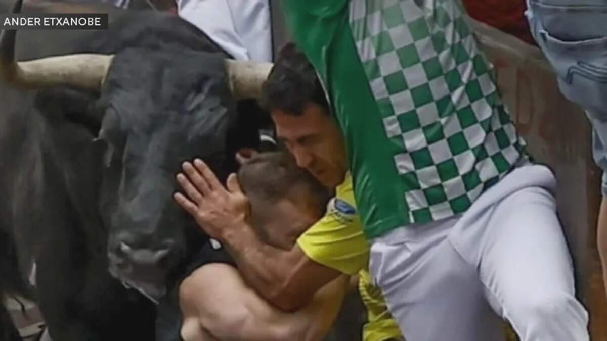 Ander Etxanobe, center with face obscured by the man in yellow, is hit by a bull in the Running of the Bulls in Pamplona, Spain, on July 10, 2026.