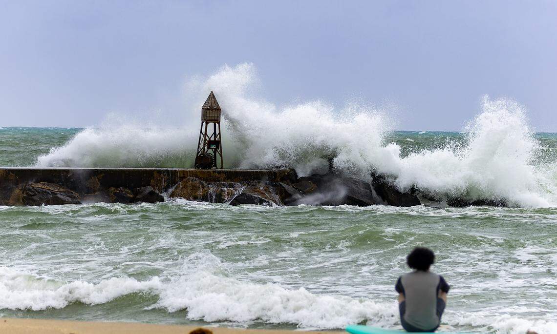 A surfer watches waves crashing against the jetty at the Bal Harbour Lighthouse on Nov. 5, 2024. This was a period of elevated rip current risk.