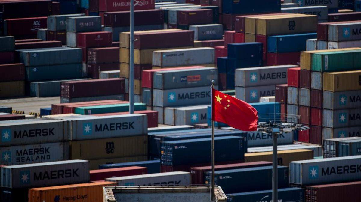 A Chinese flag flies in front of containers at the Yangshan Deep-Water Port, an automated cargo wharf, in Shanghai in 2018.
