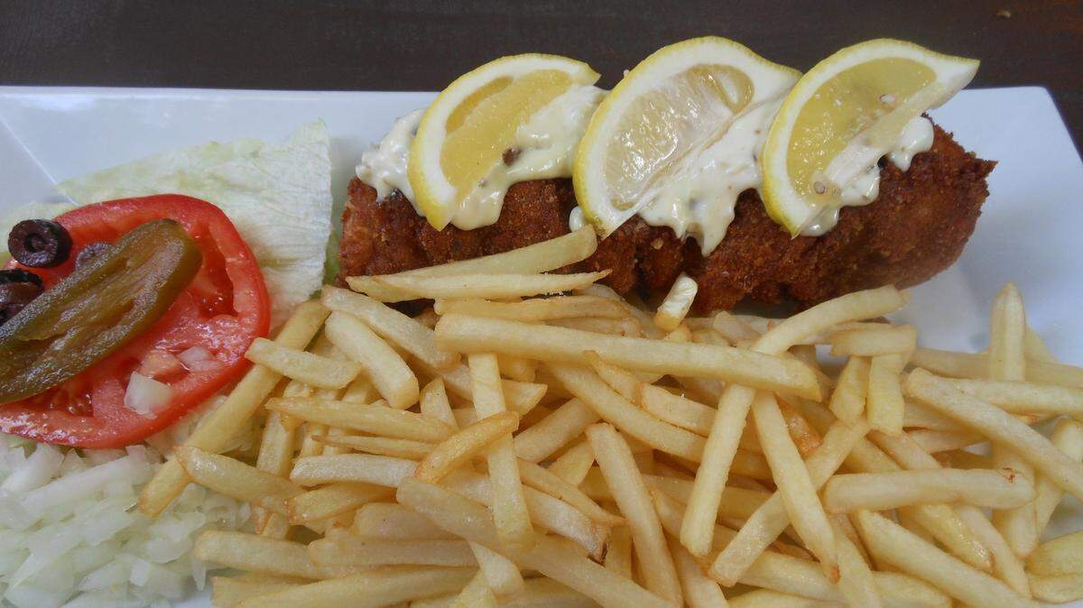 Flat burger patties with French fries and lemon at Rakija Lounge.