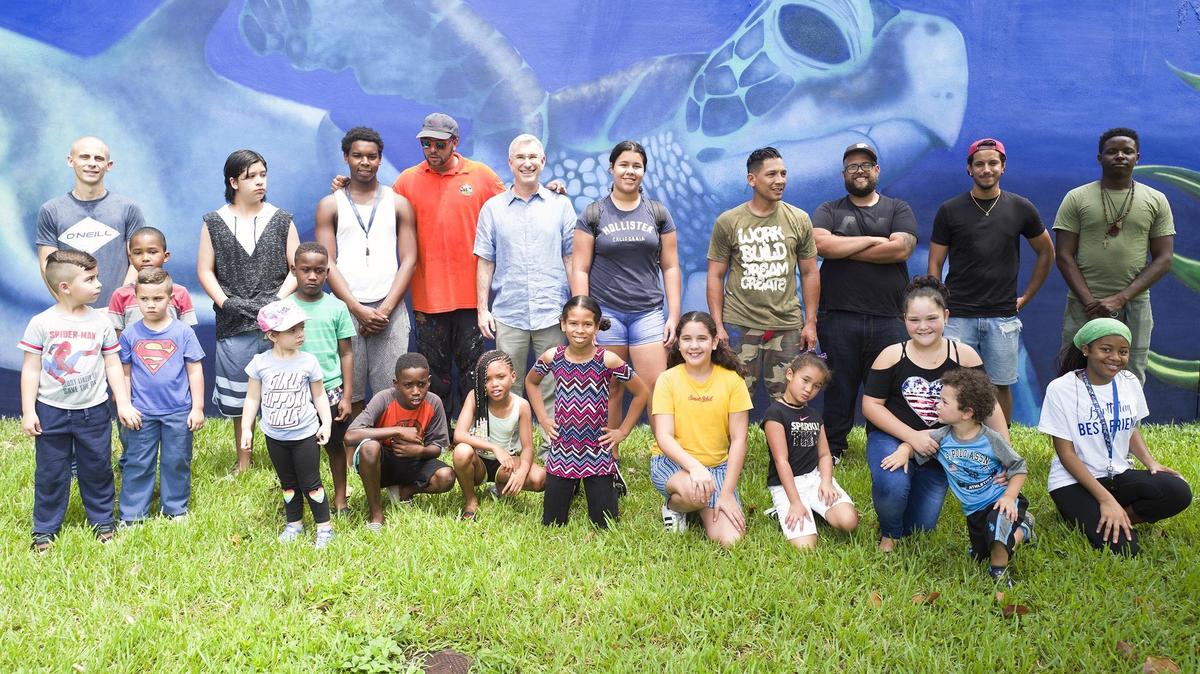 Artist and students pose in front of a Back to School Mural at Opa-Locka Kings Terrace on Saturday, August 18, 2018.  Youth were paid stipends for participation in a summer educational activity while learning painting techniques from professional artist.  Fifty-eight youth and 9 artists over 6 weeks from June 25-August 7 painted a mural with 9 diverse artists. Artists from Brazil, Peru, Haiti, Cuba, Columbia, Miami, Key West and Opa-Locka participated.