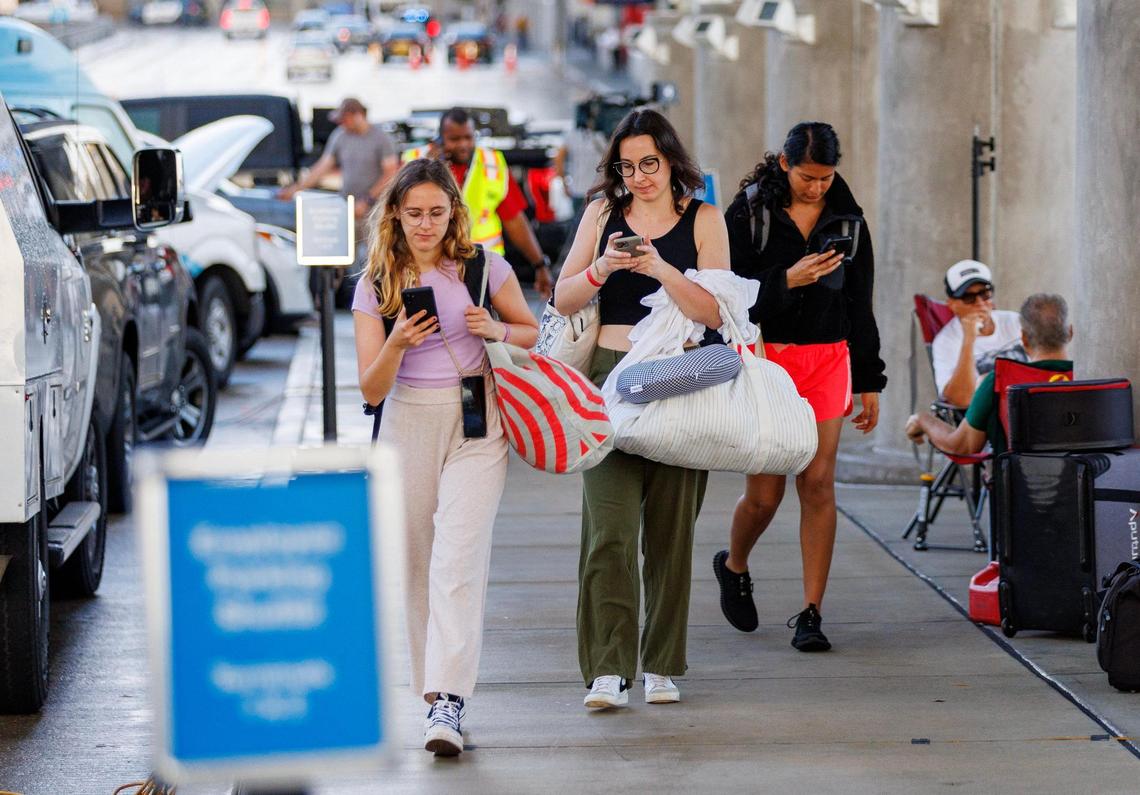 Travelers walk outside Terminal 2 at the Fort Lauderdale-Hollywood International Airport on Thursday, April 13, 2023, waiting for flights to be resumed after the relentless rain and windy conditions prompted the airport to suspend arriving and departing flights on Wednesday.