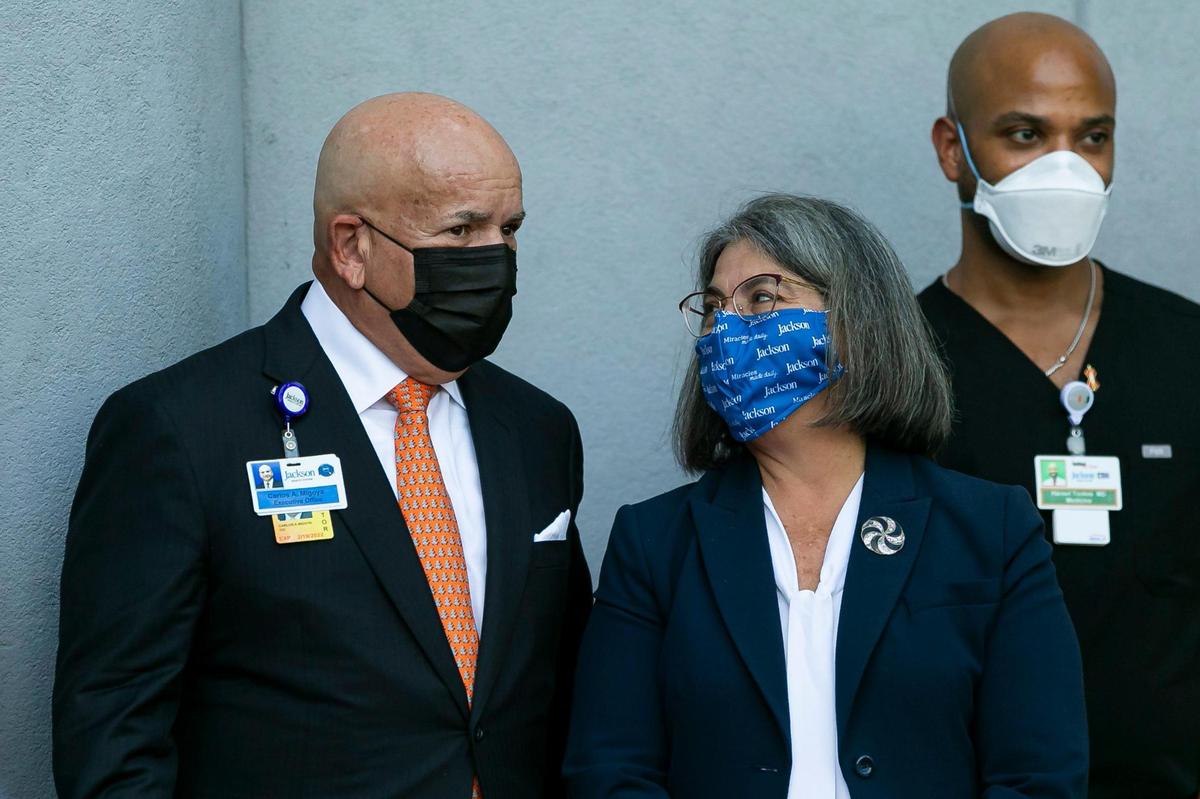 Jackson Health CEO Carlos Migoya, left, and Miami-Dade Mayor Daniella Levine Cava attend a press conference outside of Jackson Memorial Hospital in Miami, Florida, on Tuesday, Dec. 15, 2020. The conference was held after Jackson Memorial Hospital administered doses of Pfizer-BioNTech COVID-19 vaccine to its healthcare workers.