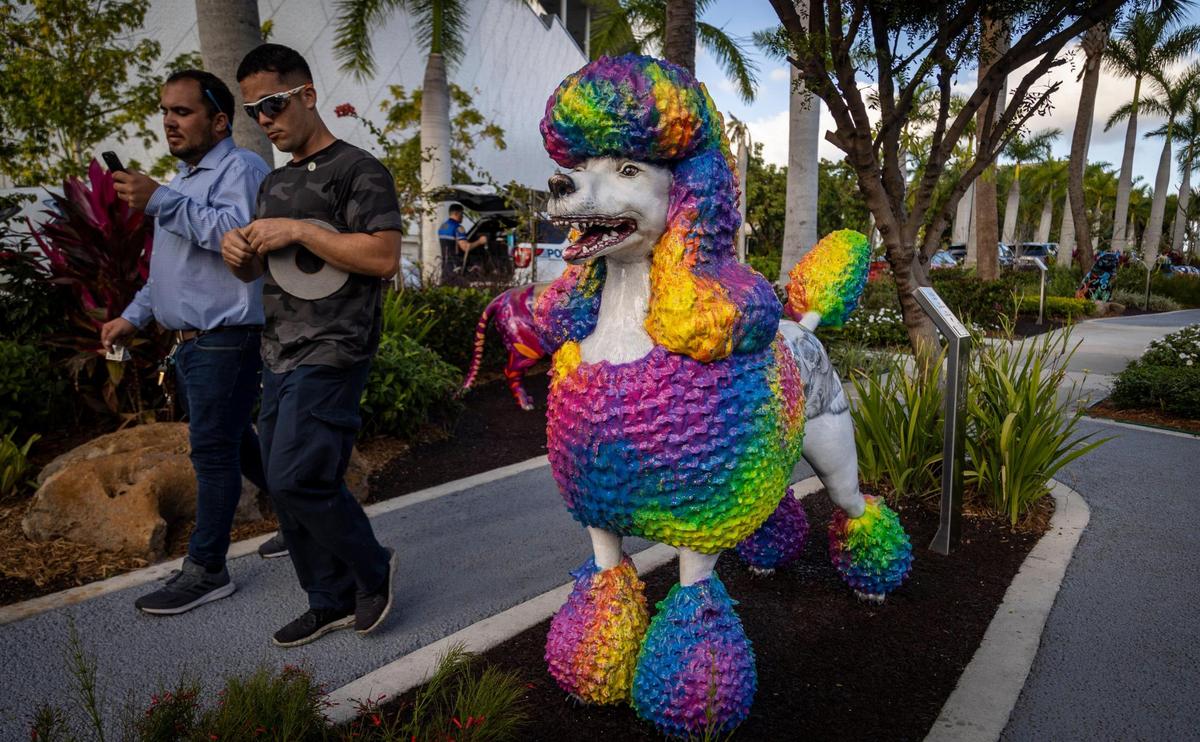 Two men walk past the statue of a Poodle at the Dogs and Cats Walkway and Sculpture Gardens. The City of Miami hosted a ribbon-cutting ceremony for the walkway and sculpture gardens at Maurice A. Ferré Park.