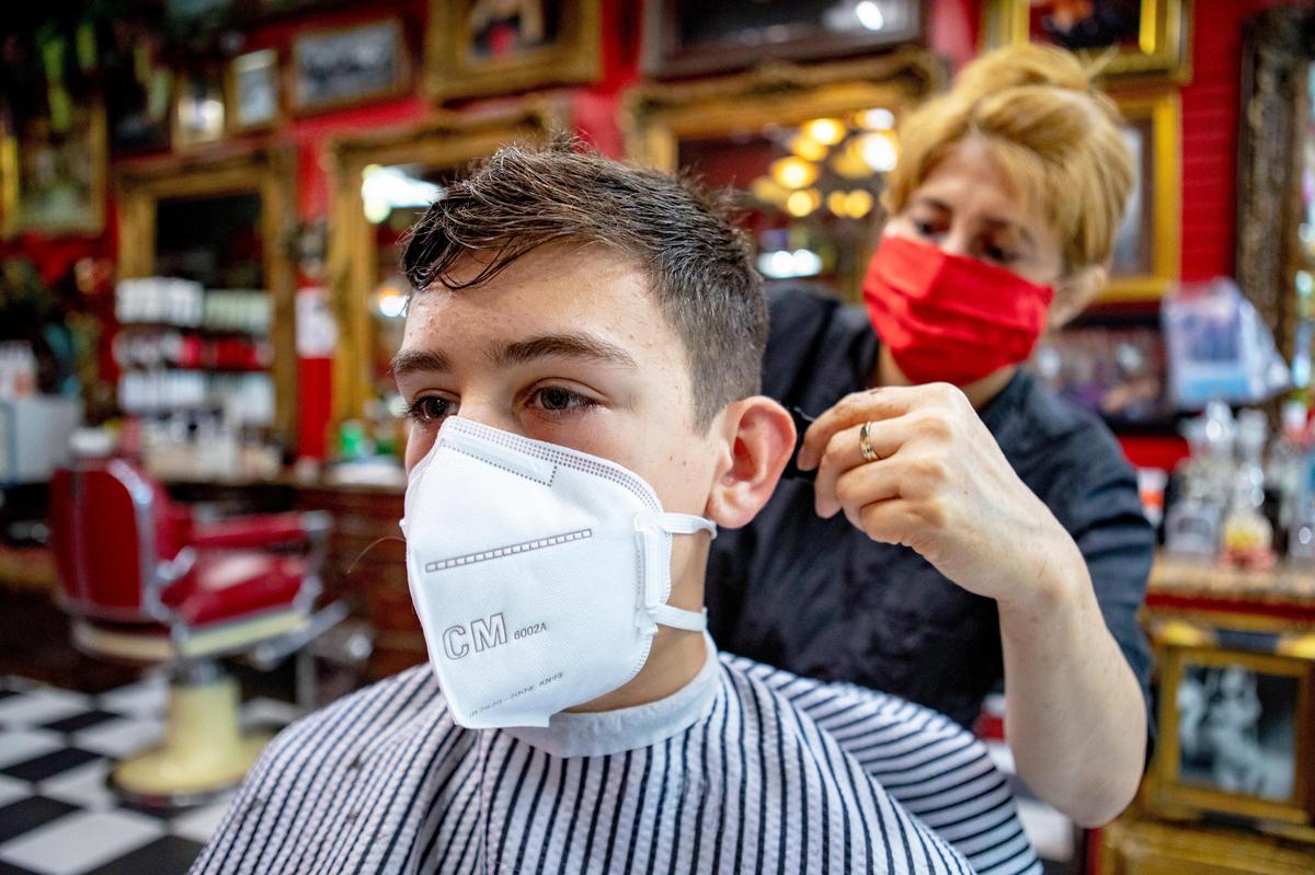 Coral Gables Preparatory Academy seventh grader Evan Noval, 13, has his hair cut as the city and county launched the first phase of the reopening process two months after the mandatory coronavirus shut down, at Razzledazzle baberbershop in Coral Gables.