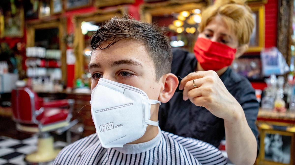 Coral Gables Preparatory Academy seventh grader Evan Noval, 13, has his hair cut as the city and county launched the first phase of the reopening process two months after the mandatory coronavirus shut down, at Razzledazzle baberbershop in Coral Gables.