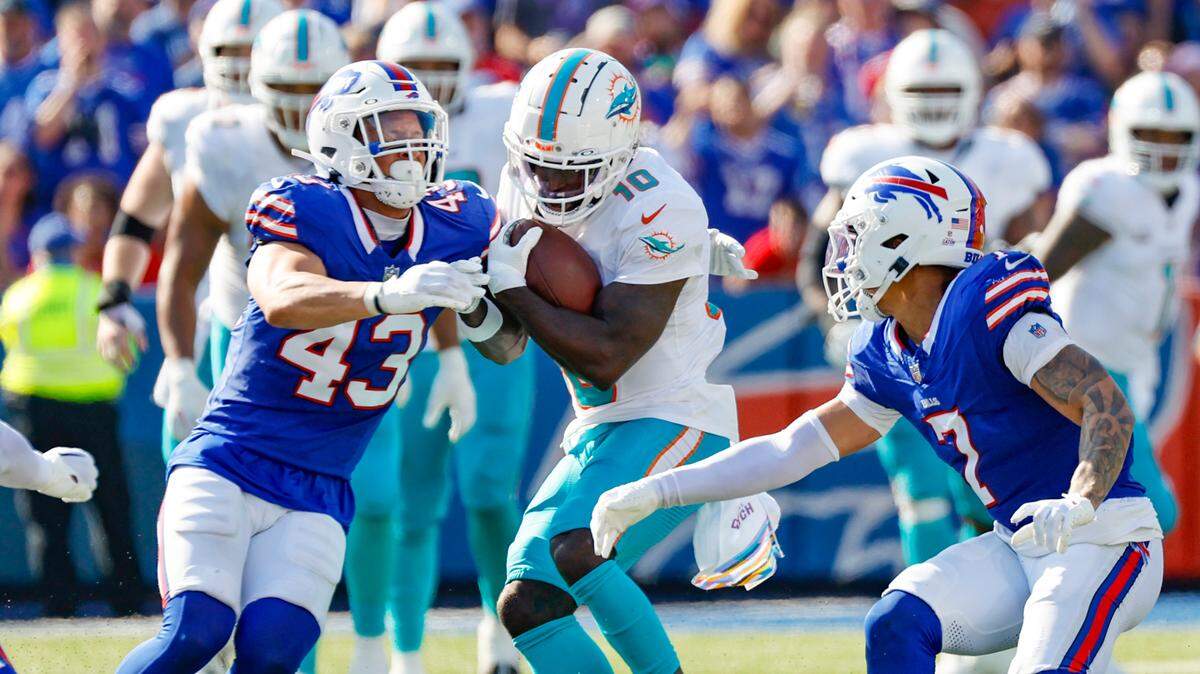 Miami Dolphins wide receiver Tyreek Hill (10) catches a pass as Buffalo Bills linebacker Terrel Bernard (43) and cornerback Taron Johnson (7) defend in the first half at Highmark Stadium in Orchard Park, NY., on Sunday, October 1, 2023.