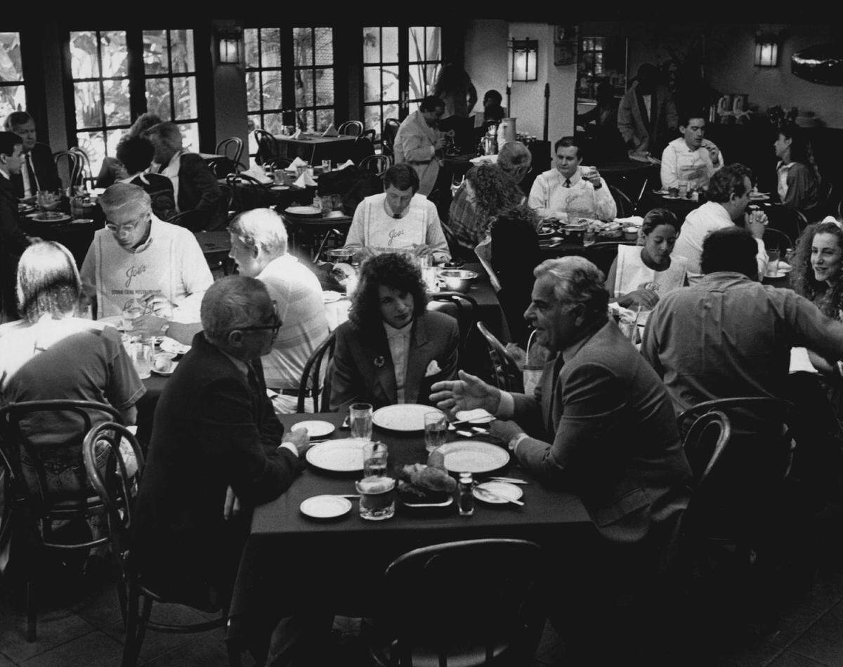 Miami Beach attorney Harold Rosen (right foreground) discusses business at Joe’s Stone Crab in 1990.