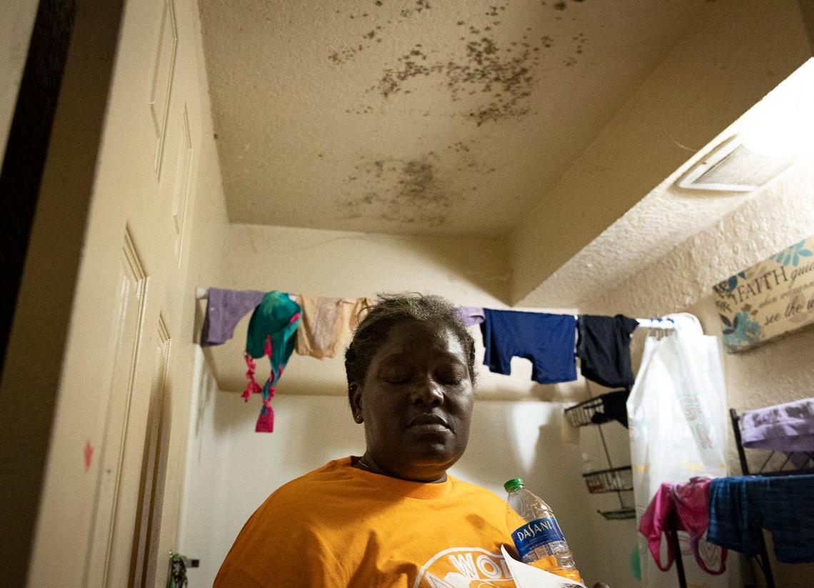 Karen Roberson, tenant since 2012, closes her eyes while standing in her bathroom with black mold on the ceiling at the Lincoln Fields Apartments on Tuesday, May 23, 2023, down the street from Liberty Square in Miami. Roberson said management has sprayed with stuff that is supposed to kill the mold and then painted over it, so the mold always returns within a few months and the bugs follow. Roberson lives with five kids many of whom have health issues and she says the mold makes it worse. “With the cost of everything going up I can’t afford to move us,” said said.
