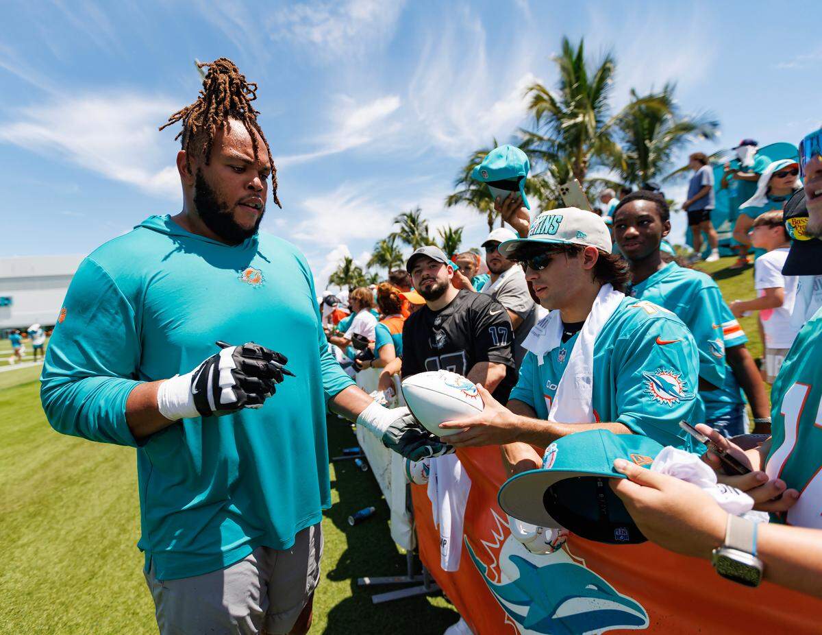 Miami Dolphins offensive linemen Robert Hunt (68) sign autographs for fans after NFL football training camp at Baptist Health Training Complex in Hard Rock Stadium on Sunday, July 30, 2023 in Miami Gardens, Florida.