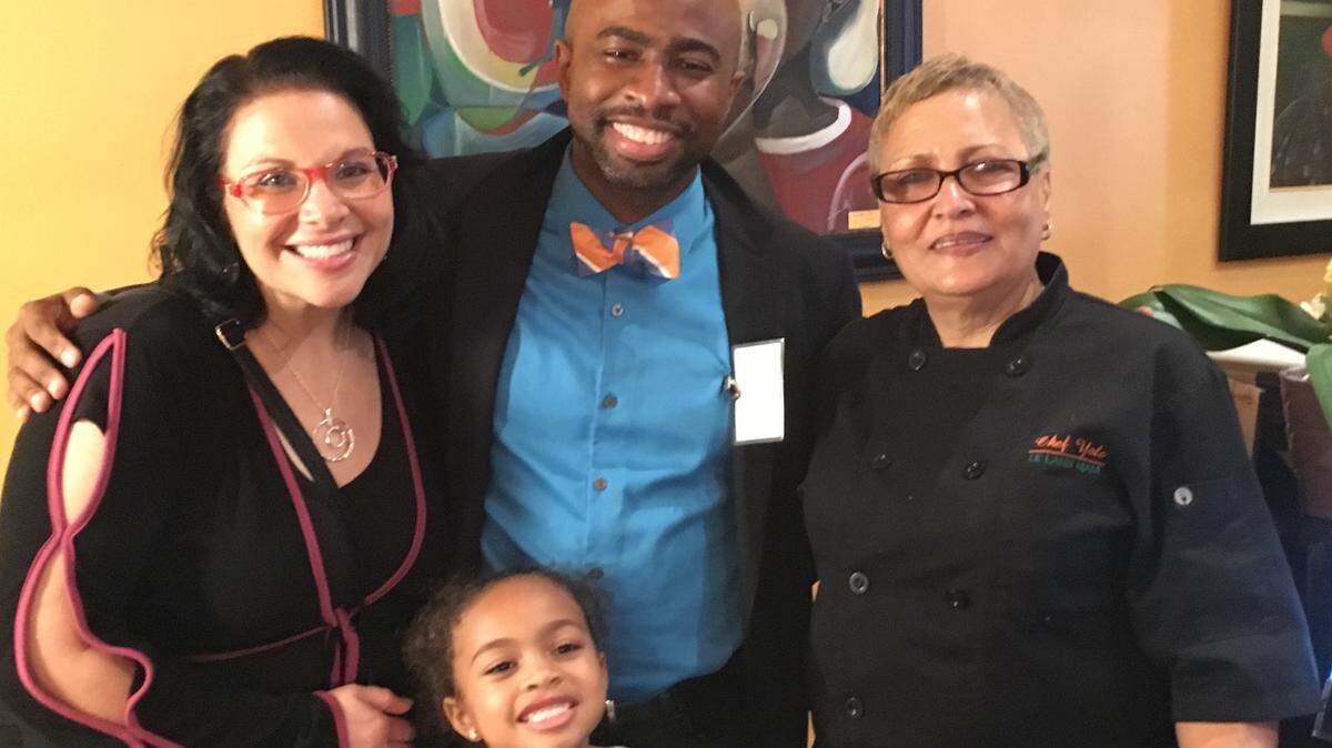 Celebrating family and friends over Haitian food are, from left, Amy Desouvre; her husband, teacher and author Yanatha Desouvre; and Chef Yole Jean-Jacques, executive chef and co-founder of Le Lambi Miami. Danielle Desouvre, 6, is in front.