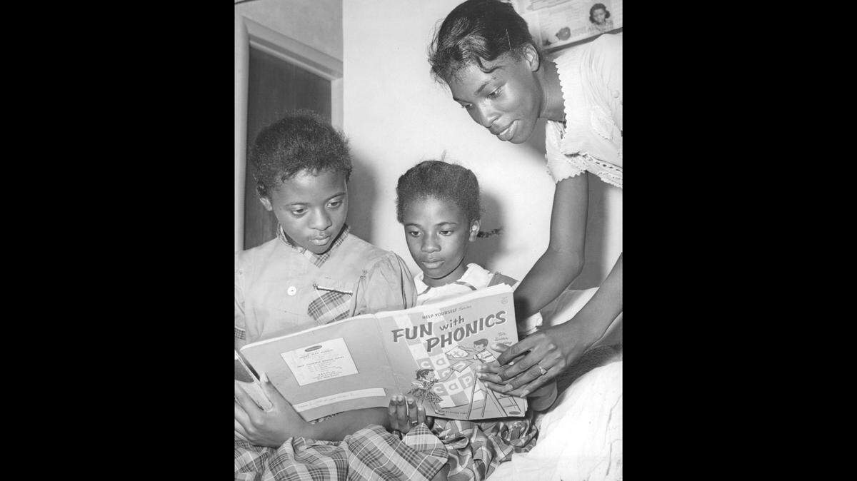 These two daughters of Mrs. Doll Pearson, right, were among the only Black pupils in white schools in South Florida in 1960. Rosetta, left, attended North Miami Beach Junior, and Barbara, center, attended Fulford Elementary.