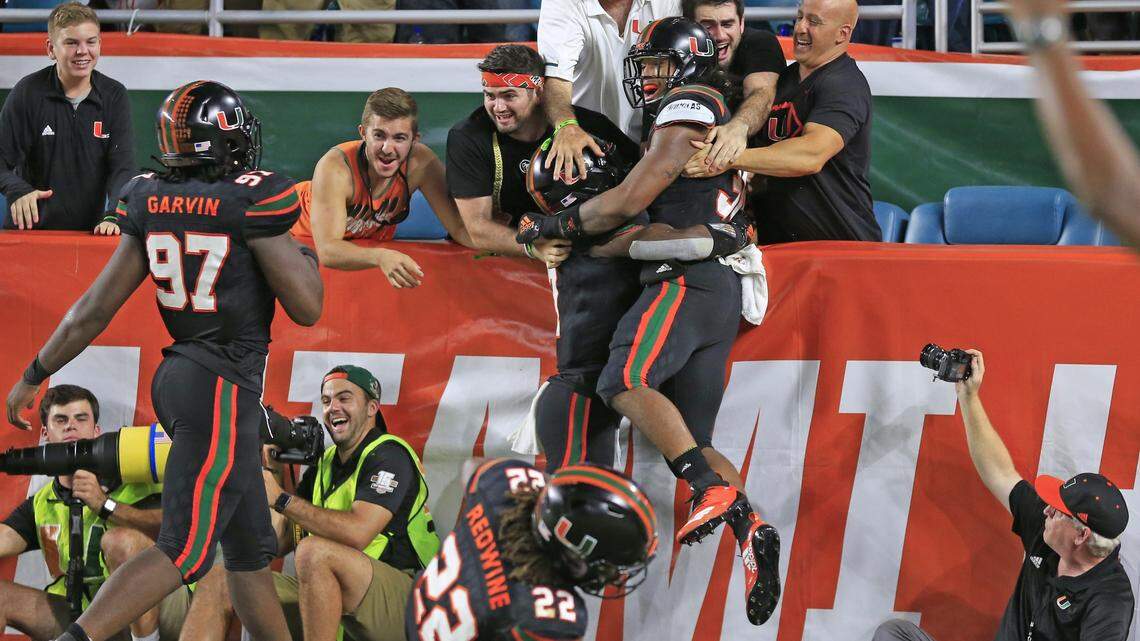 Miami Hurricanes striker Romeo Finley (30) is joined by defensive back Al Blades Jr. (7) after Finley returns an 83 yard interception for a touchdown against North Carolina at Hard Rock Stadium in Miami Gardens on Thursday, September 27, 2018.