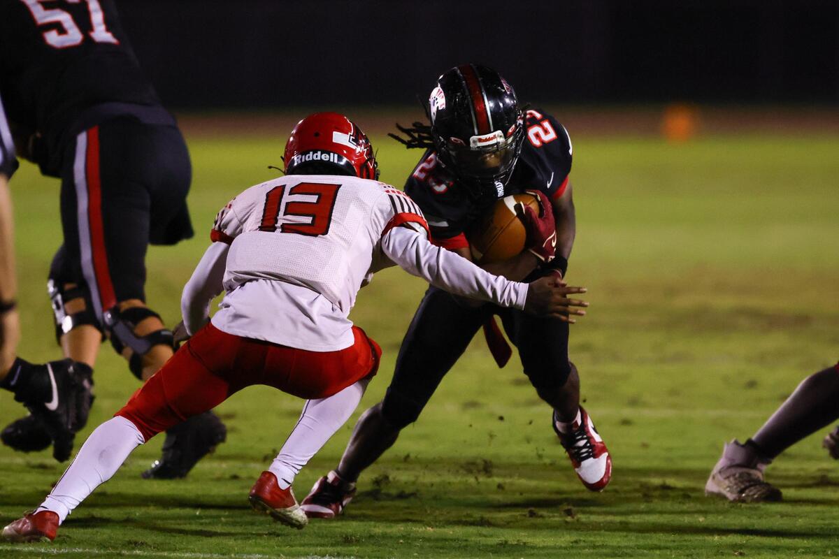 Southridge Spartans running back William Williams (23) run with the football as Monarch Knights outside linebacker Jeremy Daniels (13) attempts a tackle during the first quarter of a high school football playoff game at Southridge Park in Miami, Florida, on Friday, November 22, 2024.