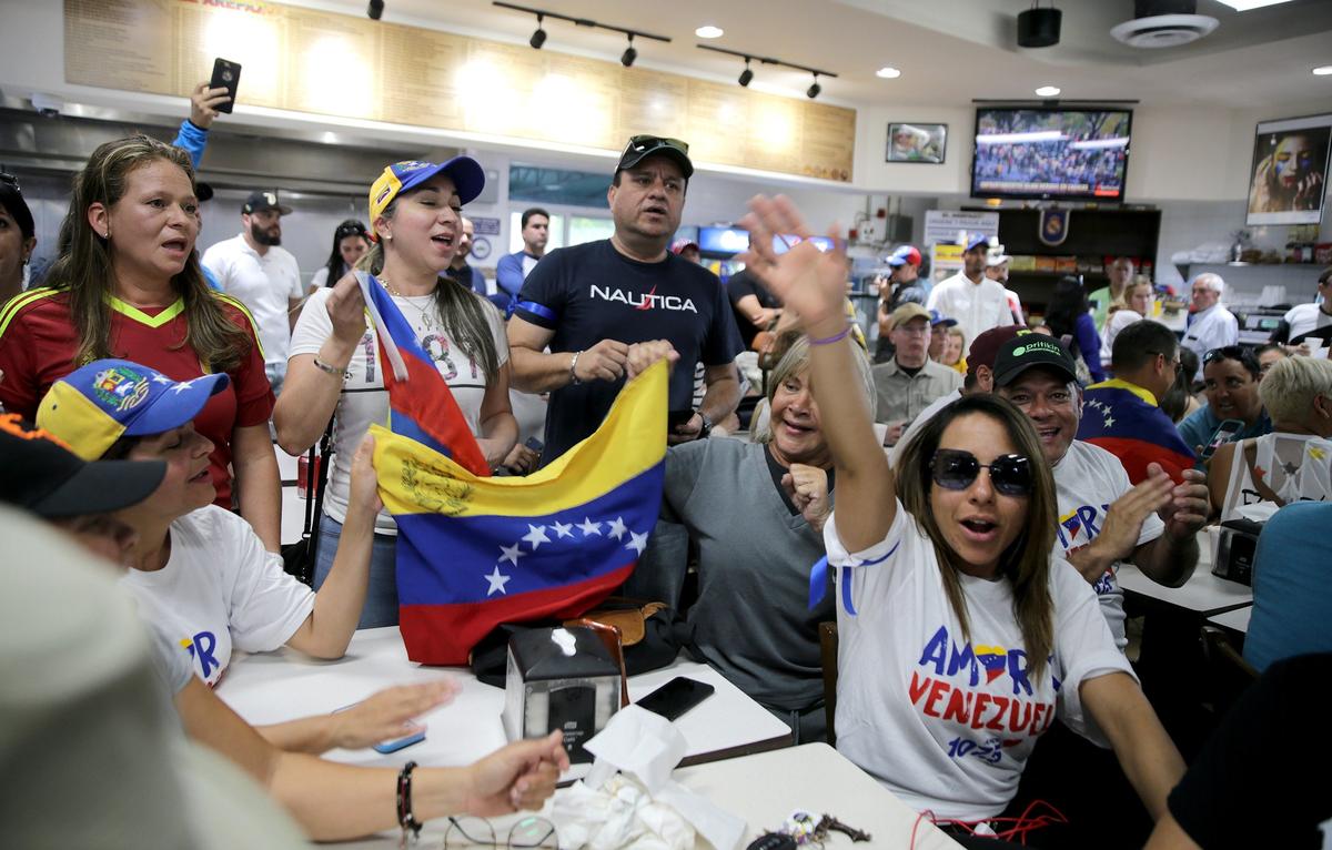 Venezuelan exiles in Miami anxiously follow news coming out of Venezuela through media outlets including television channels and social media at El Arepazo restaurant in Doral.
