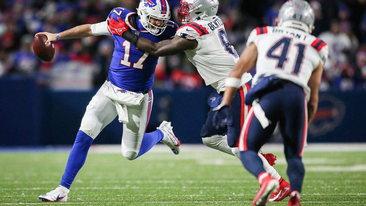 Buffalo Bills quarterback Josh Allen (17) breaks away from a tackle attempt by New England Patriots middle linebacker Ja’Whaun Bentley (8) during the second half of an NFL football game Monday, Dec. 6, 2021, in Orchard Park, N.Y. (AP Photo/Joshua Bessex)