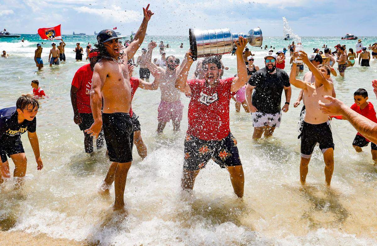 Panthers fans lift a replica trophy during the Florida Panthers Stanley Cup victory parade and rally at the beach along A1A in Fort. Lauderdale, Florida on Sunday, June 22, 2025.