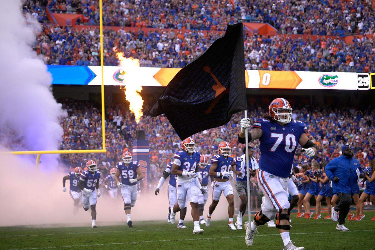 Florida offensive lineman Michael Tarquin (70) carries a flag onto the field before an NCAA college football game against Utah, Saturday, Sept. 3, 2022, in Gainesville, Fla.