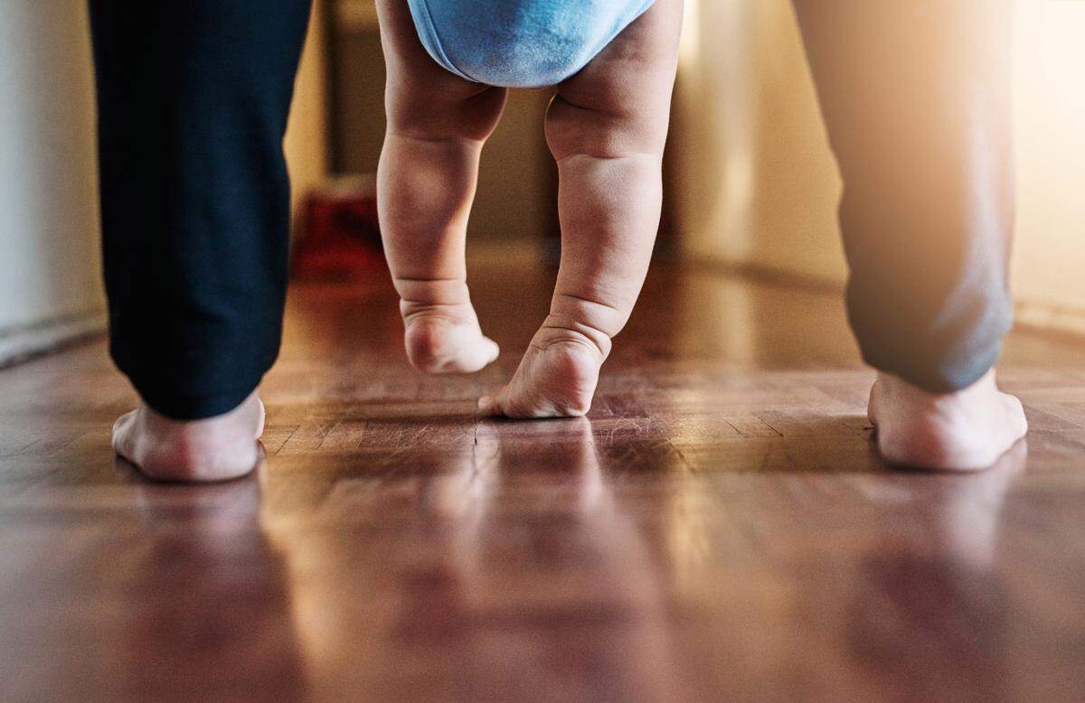 parent teaching child to walk