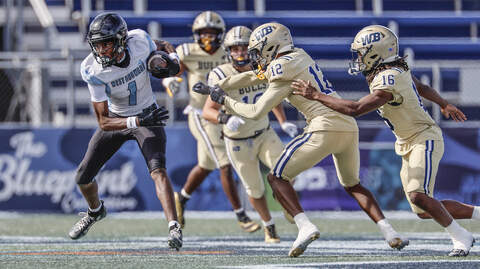 West Broward Bobcats Amir Sears (1) is chased by West Boca Raton Bulls defenders in the first half of the Class 6A, State Championship football game at FIU’s Pitbull Stadium in Miami, Florida on Friday, December 12, 2025. West Broward Bobcats Amir Sears (1) is chased by West Boca Raton Bulls defenders in the first half of the Class 6A, State Championship football game at FIU’s Pitbull Stadium in Miami, Florida on Friday, December 12, 2025.