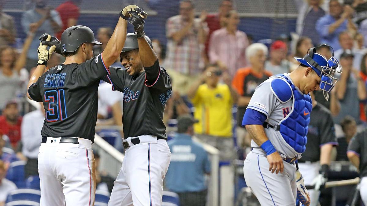 Miami Marlins Curtis Granderson (21) is met at home plate by Caleb Smith (31) after Granderson’s third inning home run as New York Mets catcher Wilson Ramos (40) stands by at Marlins Park in Miami, Florida, Friday, July, 12, 2019.
