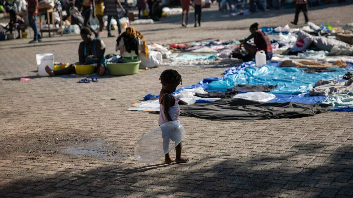 A child plays with an inflated condom at the Hugo Chavez public square transformed into a refuge for families forced to leave their homes due to clashes between armed gangs in Port-au-Prince, Haiti, Thursday, Oct. 20, 2022.