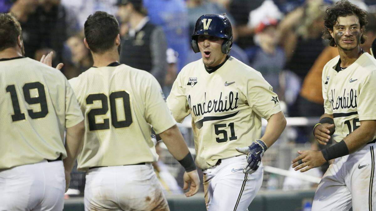 Vanderbilt’s JJ Bleday (51) celebrates with teammates after scoring against Louisville on an RBI double by Ethan Paul in the ninth inning of an NCAA College World Series baseball game in Omaha, Neb., Friday, June 21, 2019.