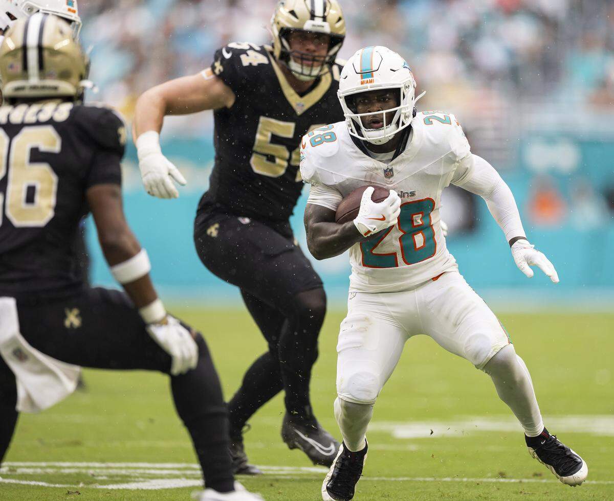 Miami Dolphins running back De'Von Achane (28) runs with the ball in the second half of his NFL game against the New Orleans Saints at Hard Rock Stadium on Sunday, Nov. 30, 2025, in Miami Gardens, Fla.