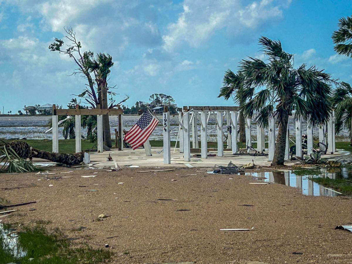 Cedar Key, Florida, 2 de octubre de 2024 - La casa sobre pilotes frente al mar que pertenecía a Jody Griffis en Cedar Island quedó destruida cuando el huracán Helene tocó tierra en Big Bend, Florida. Griffis y su esposa encontraron solo los pilotes que quedaban después de regresar al pueblo, y las comunidades circundantes quedaron igualmente devastadas. El Sr. Griffis colocó la bandera en lo que quedaba de la casa cuando pasó por la propiedad después de la tormenta.
