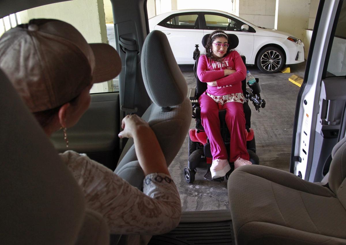 Zoraya Monsalve, left, looks back at her daughter, Valentina Corpas, 13, who has severe spina bifida and uses a custom electric wheelchair, however the chair does not fit the family car, so she is essentially homebound. Valentina is hoping for the retro-fitting a ramp on the family SUV or purchasing a new vehicle that already equipped with a wheelchair ramp. The pair were photographed on Thursday, December 20, 2018.