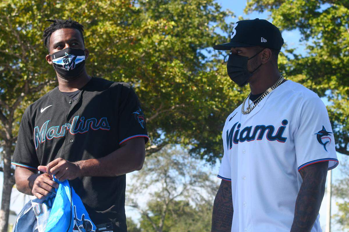Miami Marlins outfielders Lewis Brinson (left) and Monte Harrison prepare their swag bags at a Marlins Foundation toy distribution at Gwen Cherry Park for first graders at KIPP Sunrise Academy on Thursday, Dec. 10, 2020.