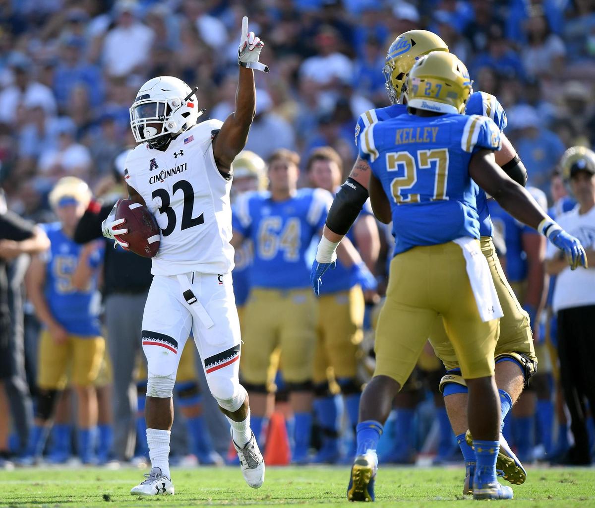 PASADENA, CA - SEPTEMBER 01: James Wiggins #32 of the Cincinnati Bearcats celebrates his interception in front of Joshua Kelley #27 of the UCLA Bruins during the second quarter at Rose Bowl on September 1, 2018 in Pasadena, California. (Photo by Harry How/Getty Images)