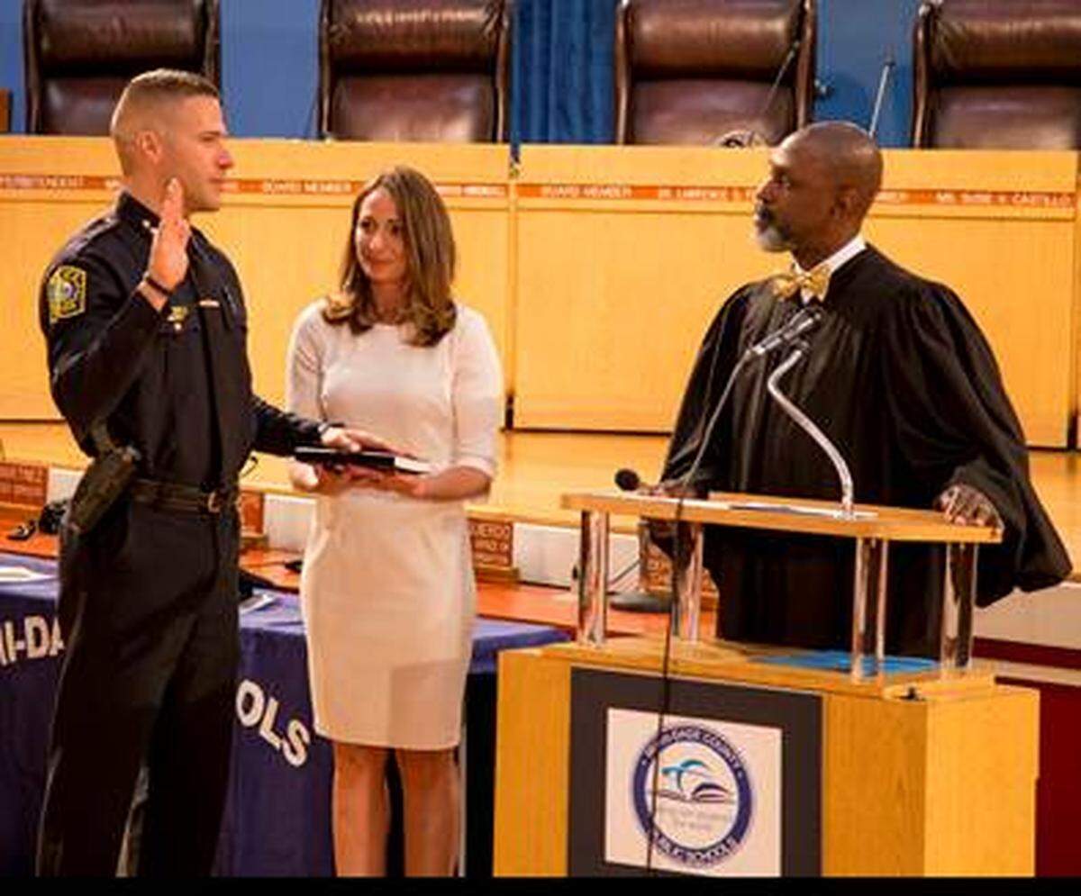 Edwin López, left, was recently sworn in as the new police chief for Miami-Dade County Public Schools during a recent school board meeting. He is pictured with his wife, Jannett López, center, and Circuit Court Judge Orlando Prescott.
