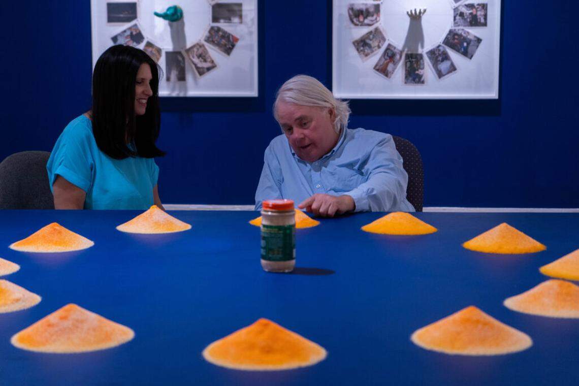 Jodi Sypher, curator at Hollywood Art and Culture Center, with Dennis Scholl discussing “A Day of Four Sunsets” running through Sunday, Jan. 4.